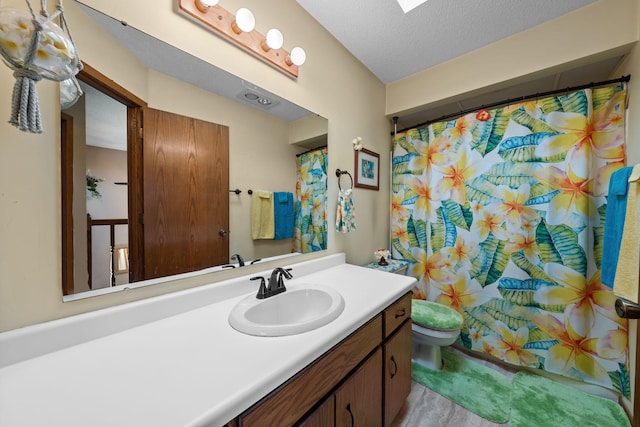 full bathroom with curtained shower, toilet, vanity, and a textured ceiling