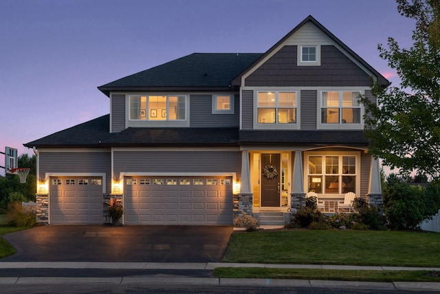 craftsman-style house featuring stone siding, asphalt driveway, a lawn, and a porch