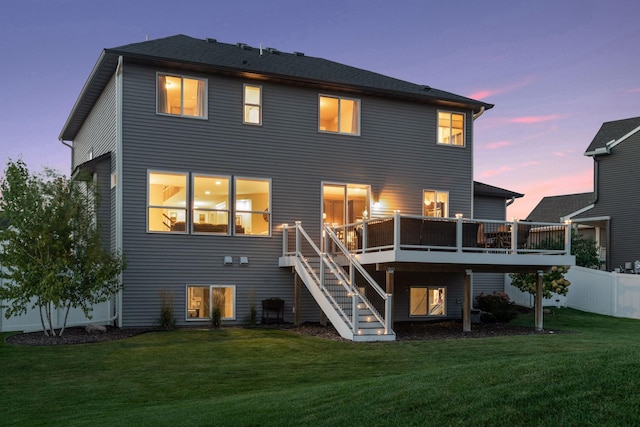 back of property at dusk featuring stairway and a deck