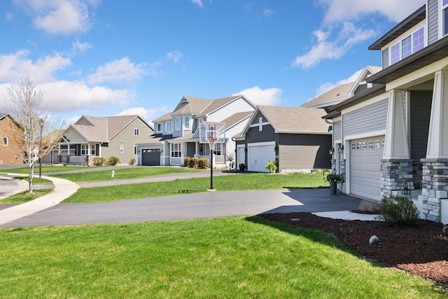 view of grassy yard featuring a residential view, concrete driveway, and a garage