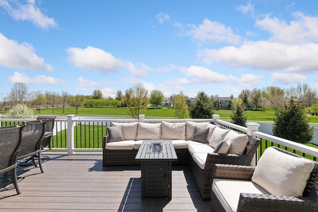 wooden deck featuring an outdoor living space with a fire pit and a yard