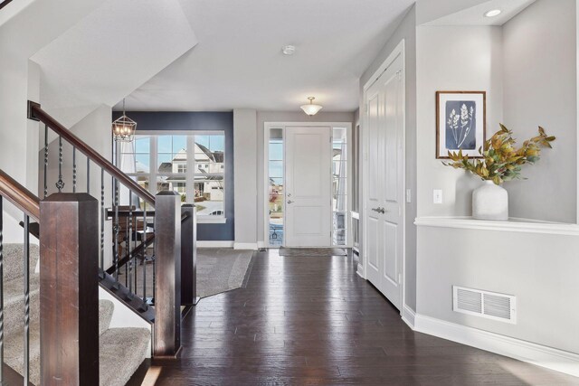 entrance foyer with baseboards, a chandelier, and stairs