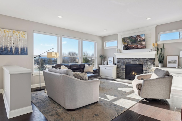 living room with wood finished floors, baseboards, a fireplace, and recessed lighting