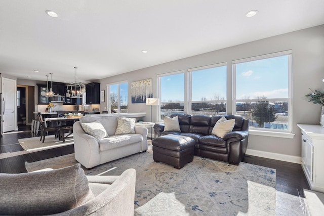 living room featuring a chandelier, wood finished floors, baseboards, and recessed lighting