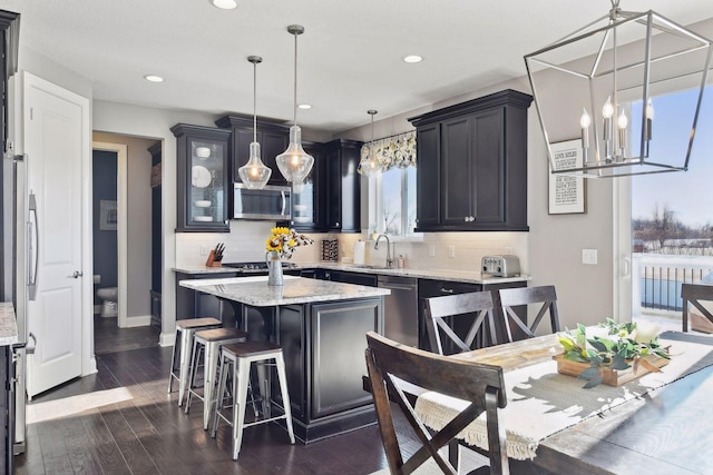 kitchen with stainless steel appliances, a center island, backsplash, a chandelier, and recessed lighting