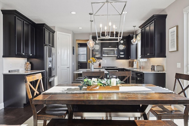 dining space featuring a chandelier, wood finished floors, and recessed lighting