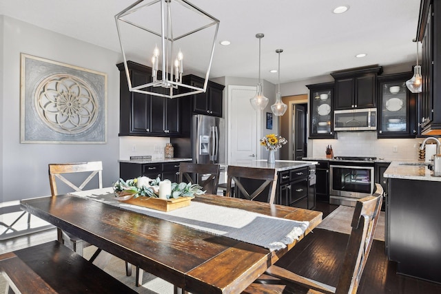 dining room with recessed lighting, wood finished floors, and a chandelier