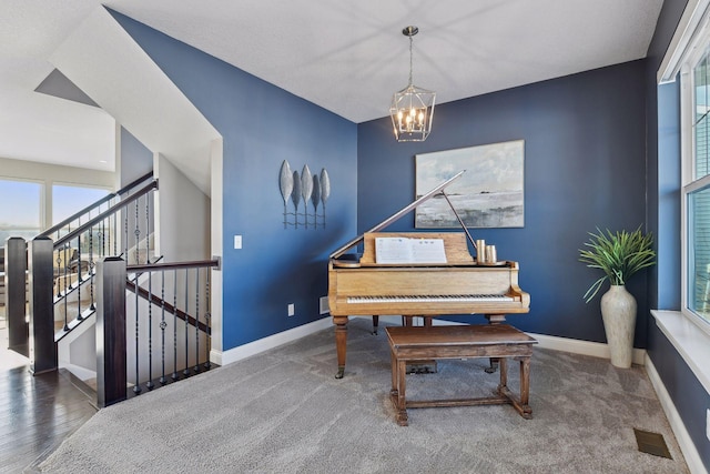 sitting room with a chandelier, baseboards, stairway, and carpet