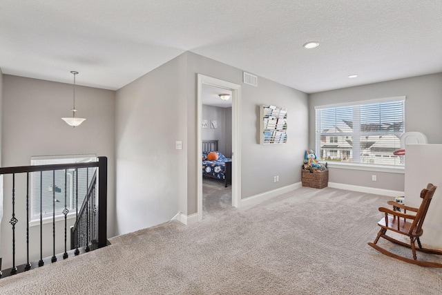 sitting room featuring an upstairs landing, carpet floors, baseboards, a textured ceiling, and recessed lighting