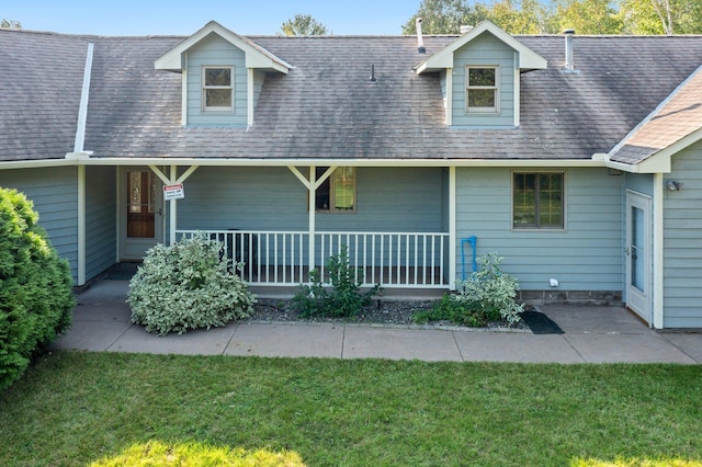 back of property with a yard and covered porch