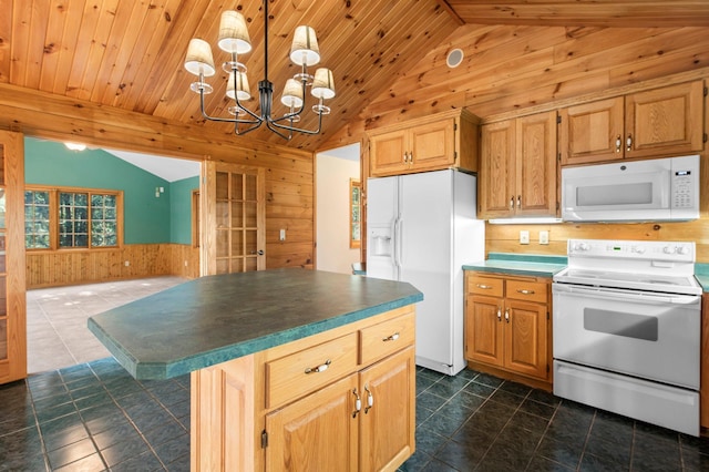 kitchen featuring dark tile patterned floors, white appliances, a kitchen island, and an inviting chandelier