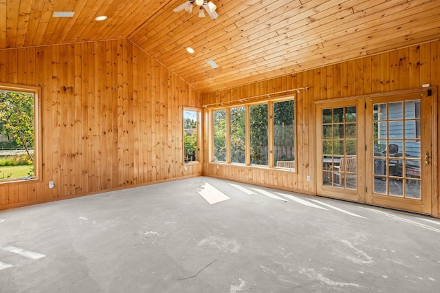 empty room with concrete flooring, vaulted ceiling, ceiling fan, and a healthy amount of sunlight