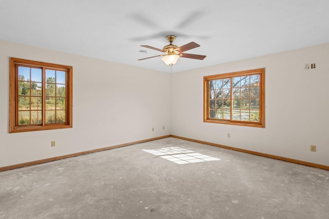 empty room with ceiling fan and concrete flooring