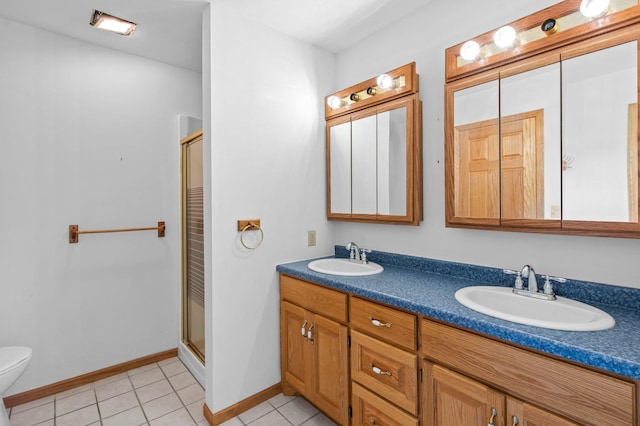 bathroom with tile patterned floors, vanity, toilet, and a shower with shower door