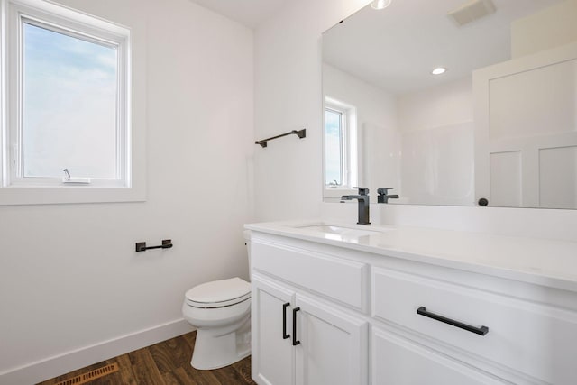 bathroom featuring vanity, hardwood / wood-style flooring, toilet, and a wealth of natural light