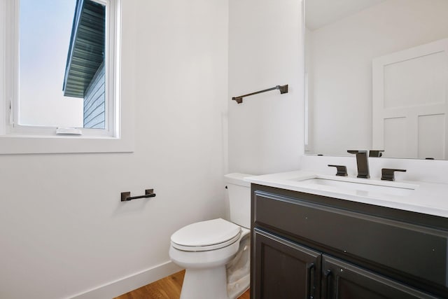 bathroom with hardwood / wood-style floors, vanity, and toilet