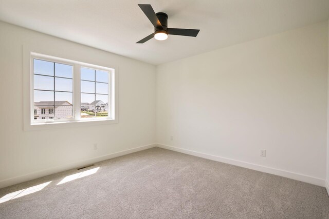 carpeted spare room with ceiling fan