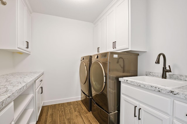 washroom featuring cabinets, hardwood / wood-style flooring, washer and dryer, and sink