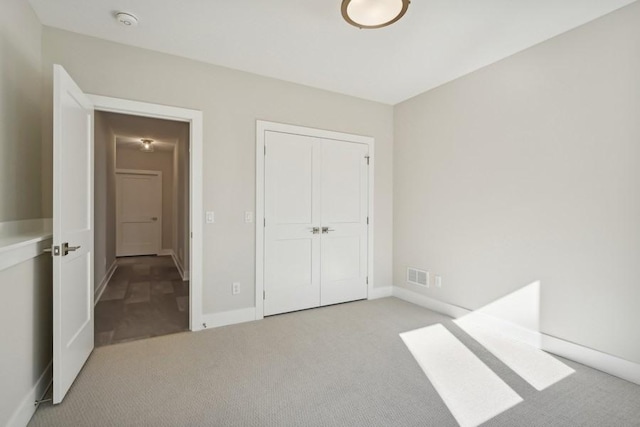 unfurnished bedroom with light carpet and a closet