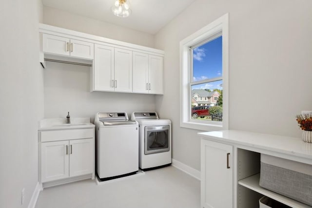 washroom featuring separate washer and dryer, sink, and cabinets