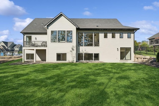 rear view of property with a lawn and a balcony