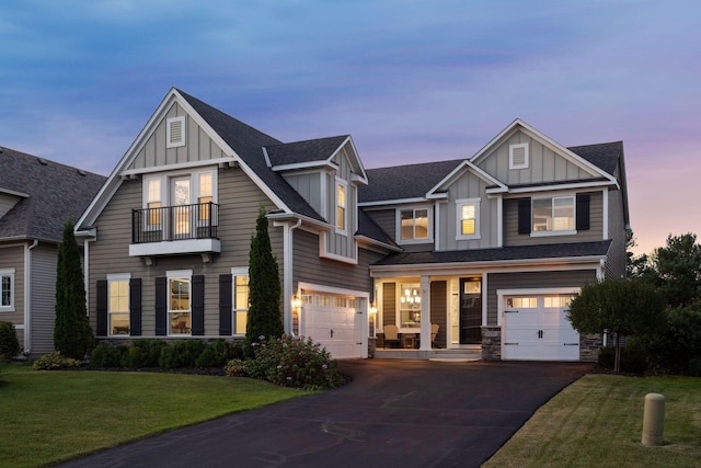 view of front of property with a garage, a balcony, and a lawn