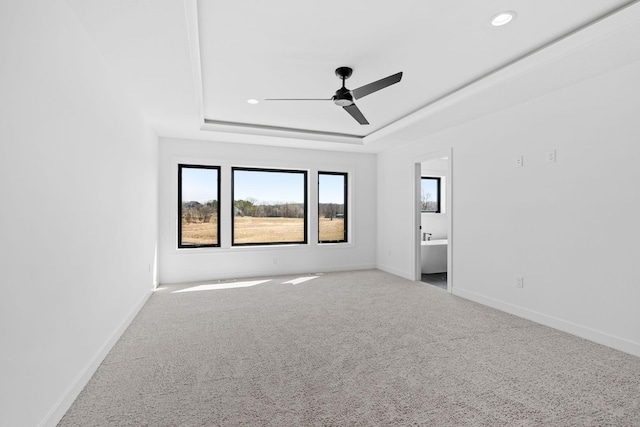 carpeted empty room featuring ceiling fan and a tray ceiling