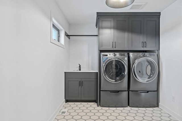 laundry area featuring sink, cabinets, and washer and dryer