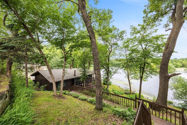 view of yard with a deck with water view