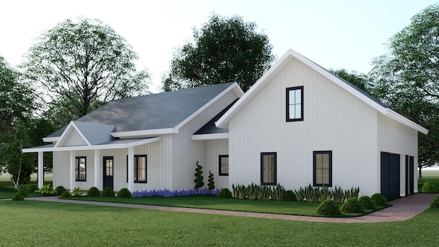 modern farmhouse style home with covered porch, a front yard, and a garage