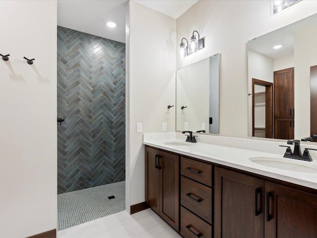 bathroom featuring tile patterned floors, vanity, and a tile shower