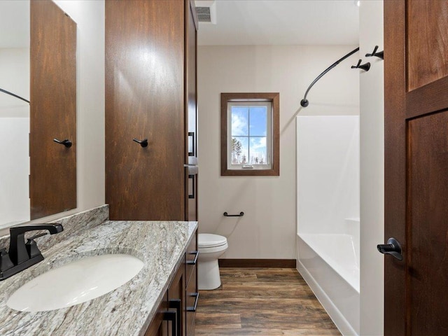 full bathroom featuring toilet, hardwood / wood-style floors, vanity, and tub / shower combination