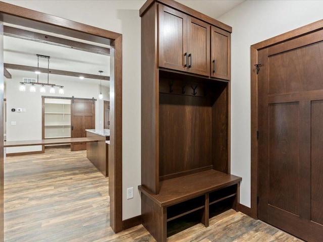 mudroom with light wood-type flooring and a barn door