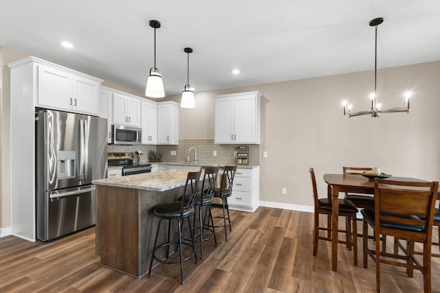 kitchen with white cabinetry, stainless steel appliances, dark hardwood / wood-style floors, and pendant lighting