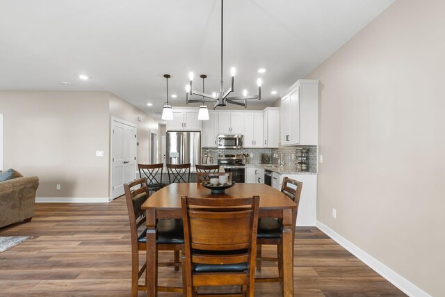 dining area featuring hardwood / wood-style flooring, a chandelier, and sink