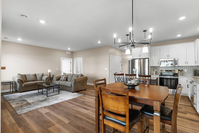 dining room featuring dark hardwood / wood-style flooring and an inviting chandelier