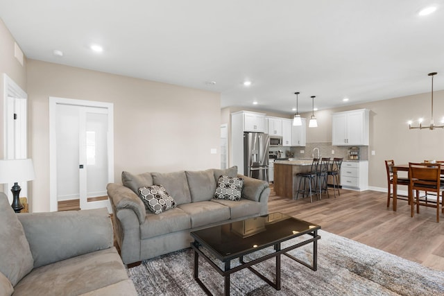 living room featuring an inviting chandelier and light hardwood / wood-style floors