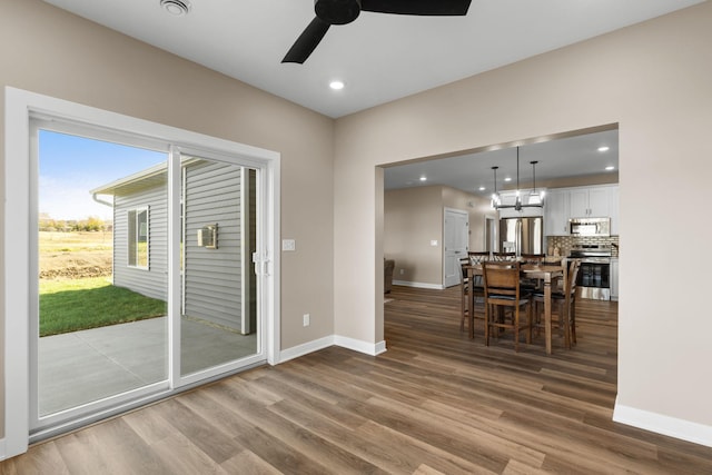 dining space with hardwood / wood-style floors and ceiling fan