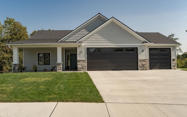 craftsman-style house with a garage, covered porch, and a front lawn