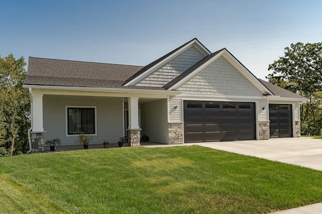 craftsman house with a porch, a front yard, and a garage