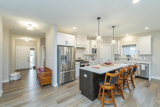 kitchen with a center island, plenty of natural light, stainless steel appliances, and white cabinetry