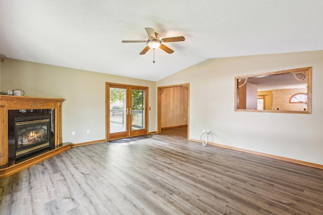 unfurnished living room featuring ceiling fan, hardwood / wood-style flooring, lofted ceiling, and a textured ceiling