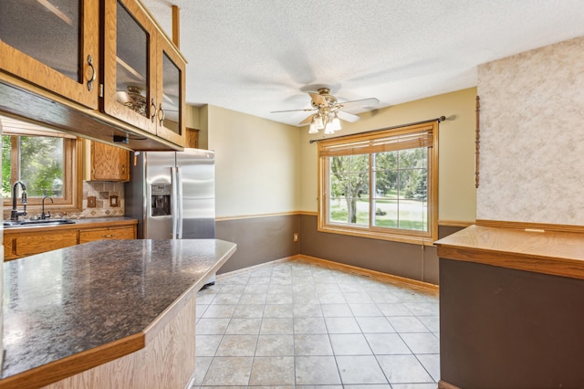 kitchen with ceiling fan, stainless steel refrigerator with ice dispenser, plenty of natural light, and sink