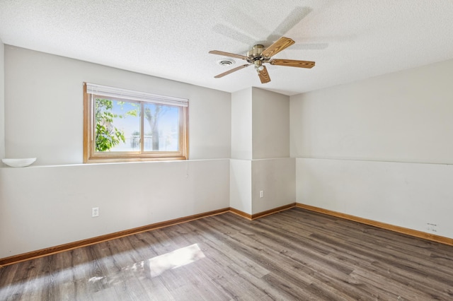 spare room featuring ceiling fan, hardwood / wood-style flooring, and a textured ceiling