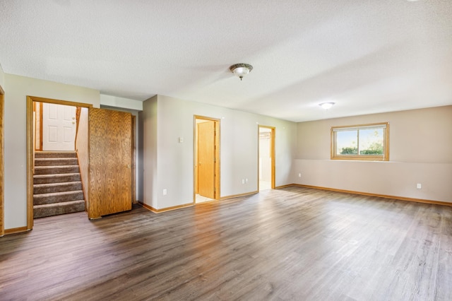 spare room with a textured ceiling and hardwood / wood-style floors