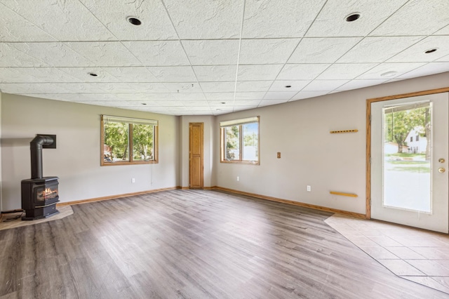 unfurnished living room with a wood stove and light wood-type flooring