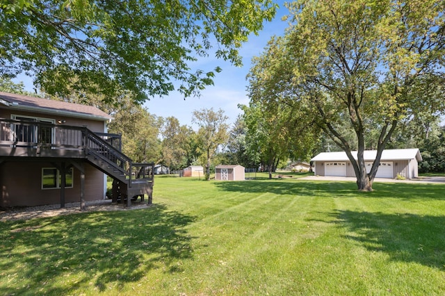 view of yard featuring a garage, a wooden deck, and a shed