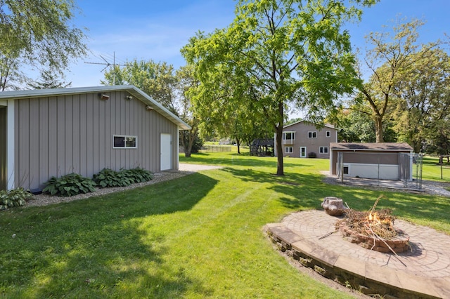 view of yard with an outdoor structure and an outdoor fire pit