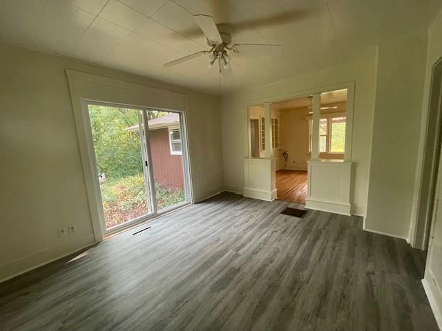 empty room featuring dark wood-type flooring and ceiling fan