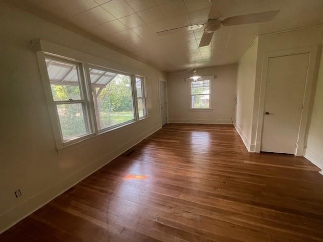 spare room with dark wood-type flooring and ceiling fan